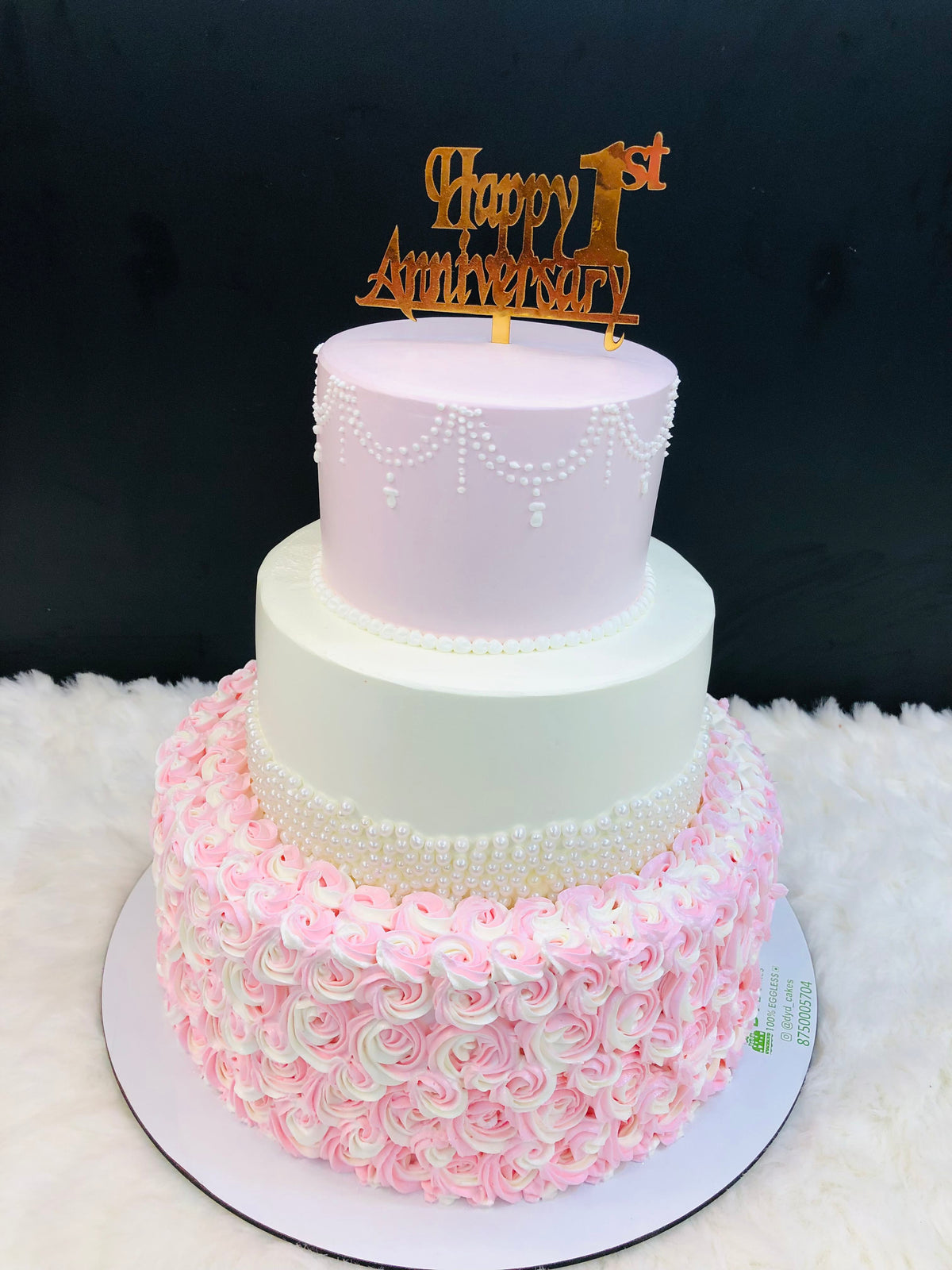 A beautifully crafted three-layer cake featuring delicate pink and white icing, perfect for celebrations.